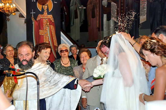 A Greek Orthodox Wedding - The priest leads Aggeliki and David.