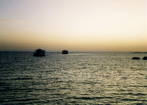 Two small ferries from Agia Roumeli and Loutro race the sunset for Chora Sfakion.