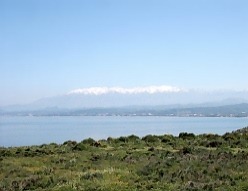 Coastline Maleme to Chania from road to Afrata. Snow-capped white mountains.